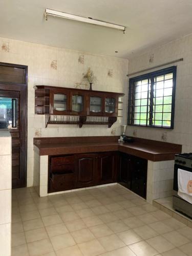 a large kitchen with wooden cabinets and a window at MJ Marina in Mtwapa