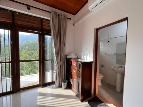a bathroom with a sink and a toilet and a window at Oli Villa in Belihuloya