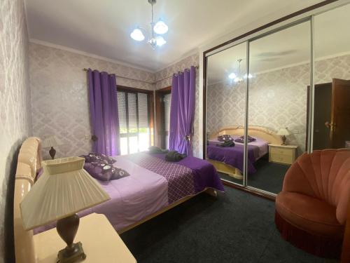 a bedroom with two beds and a lamp and a chair at Casa Boa Nova Valadares in Valadares