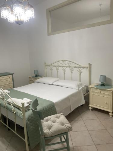 a bedroom with a bed and a chair and a chandelier at Casa Kate in Scanzano
