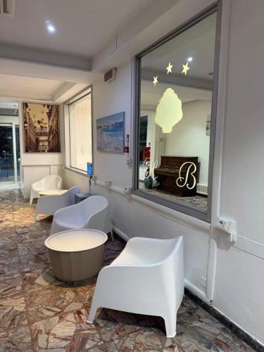 a waiting room with white chairs and a window at Hotel BENGASI Marina Centro in Rimini