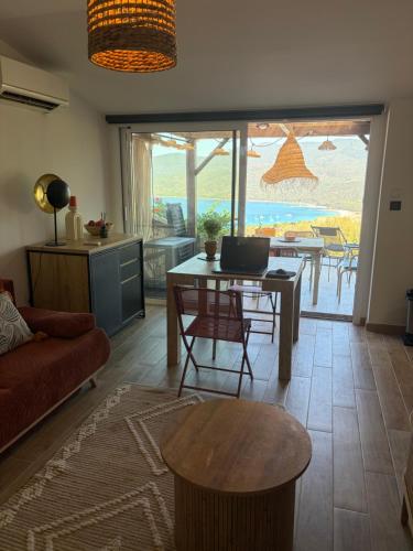 a living room with a table and a view of the ocean at La bergerie de Cupabia in Serra-di-Ferro