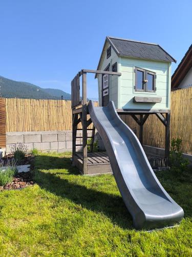 a slide in a yard with a house at Chata Valeriana Liptov in Ižipovce