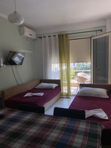 a bedroom with two beds and a window at Duki's Apartments in Orikum