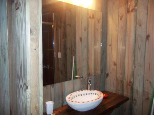 Un baño con un lavabo y un espejo. en Cabaña de Silvina, en La Pedrera