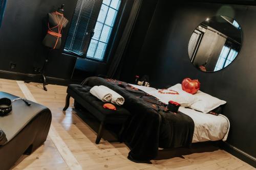 a bedroom with a bed and a mirror at La Maison Coquine Love Room Balnéo in Béthune