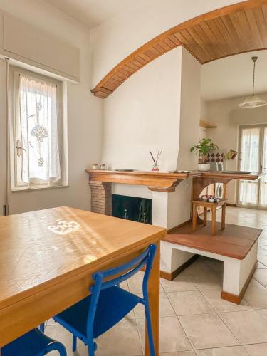 a kitchen with a wooden table and a fireplace at Lido di Camaiore-Spacious & Bright 2Bedrooms House in Lido di Camaiore