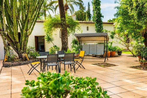 a patio with a table and chairs in a yard at Pink Lemon House in Elche