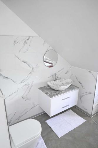 a white bathroom with a sink and a toilet at U Edzia in Kochoń
