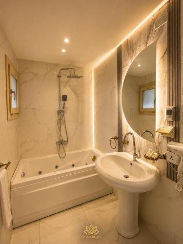 a bathroom with a sink and a tub and a toilet and a mirror at Grand lotus hotel downtown in Cairo