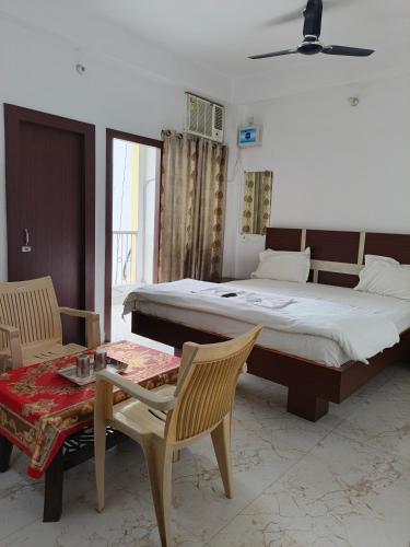 a bedroom with a bed and a table and chairs at Hotel Jaipur Royal in Patna