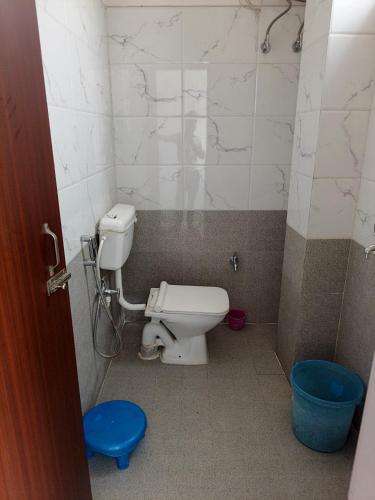 a bathroom with a toilet and a blue stool at Hotel Jaipur Royal in Patna