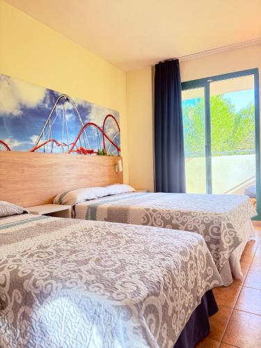 a hotel room with two beds and a window at Cap Salou Binda Mar Apartment in Salou