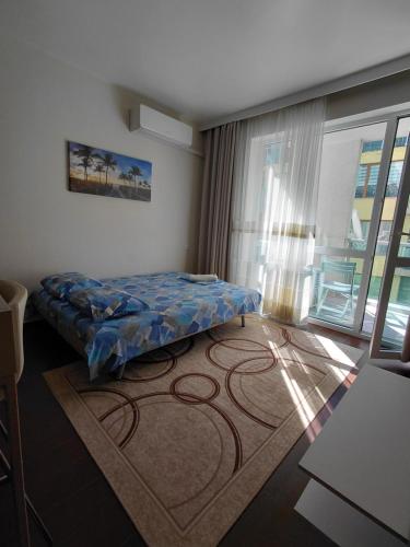 a bedroom with a bed and a large window at Апартаменти и стаи Анхиало in Pomorie