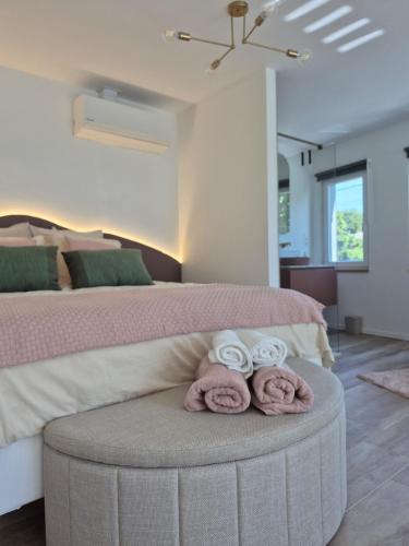 a bedroom with a bed with towels on a table at Maison H - Logement de luxe avec jacuzzi privé et home cinéma immersif in Herstal