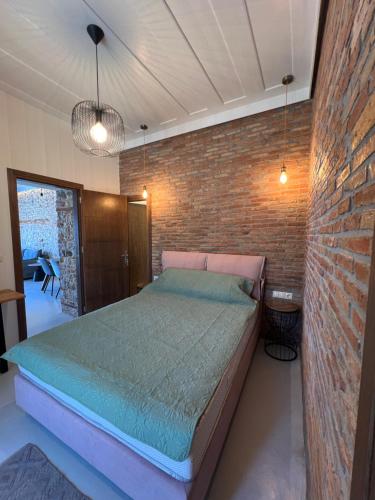 a bedroom with a bed and a brick wall at Effies Apartments in Karlovasi