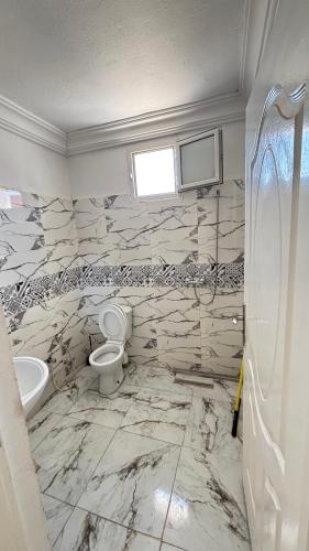 a bathroom with a toilet and a sink at hôtel Kridane in Houmt Souk