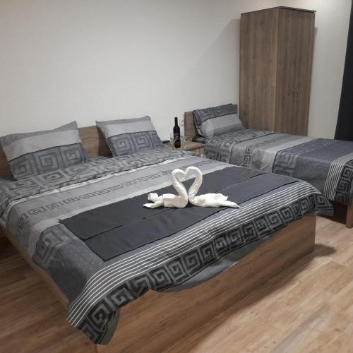 two beds with white swans on them in a bedroom at Apartments Viktor in Trpejca
