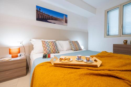 a bedroom with a bed with a tray of food on it at LOGGIATO HOUSE-Ispica in Ispica