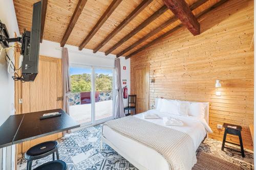 a bedroom with a bed and a desk and a window at Villas de Cintra in Sintra