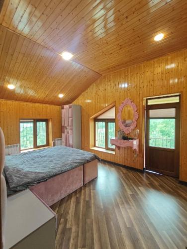 a bedroom with a bed in a room with wooden walls at Family Villa with Pool in Əski İqrığ