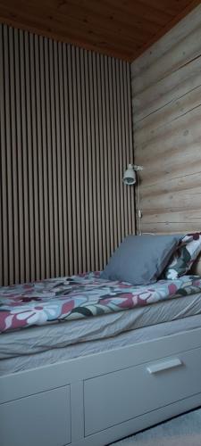 a bed in a room with a wooden wall at Solar eclipse Iceland Small studio in Kjalarnes in Reykjavík