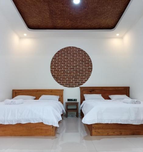 two beds in a room with a large mirror at Tereng Wilis Jungle Inn in Tetebatu