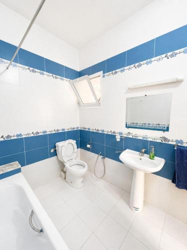 a blue and white bathroom with a toilet and a sink at Superb apartment Monastir in Monastir