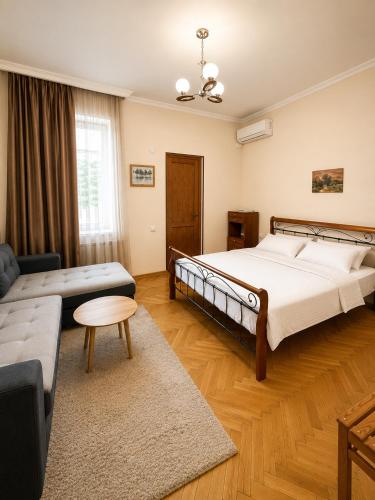 a bedroom with a large bed and a couch at Guest House Gardenia & Wine Cellar in Lagodekhi