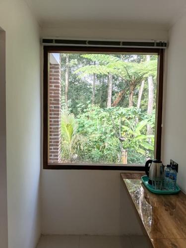 a window in a room with a view of a forest at Tereng Wilis Jungle Inn in Tetebatu