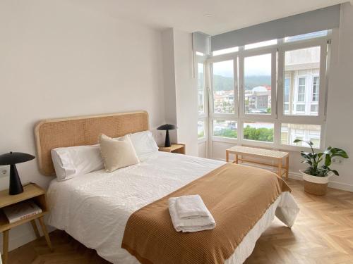 a bedroom with a large bed with a large window at Praia - Boa Onda in Cee