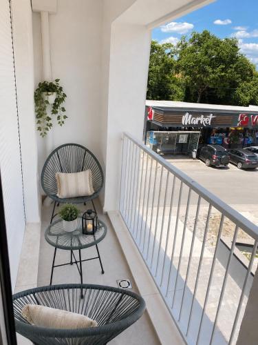 a balcony with two chairs and a table at Our story Apartment in Milovići