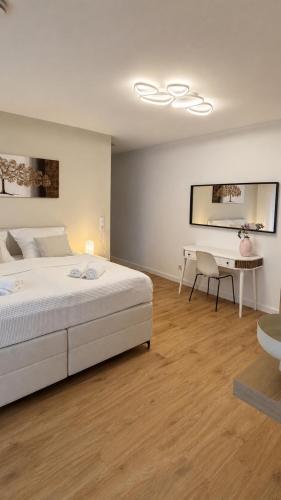 ein weißes Schlafzimmer mit Bett und Schreibtisch in der Unterkunft NOVA Living, Balkon, Nähe Altstadt & kostenlose Tiefgarage in Würzburg