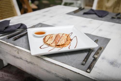 a plate with a sandwich on a table with a sauce at W15 Escape in Ahangama