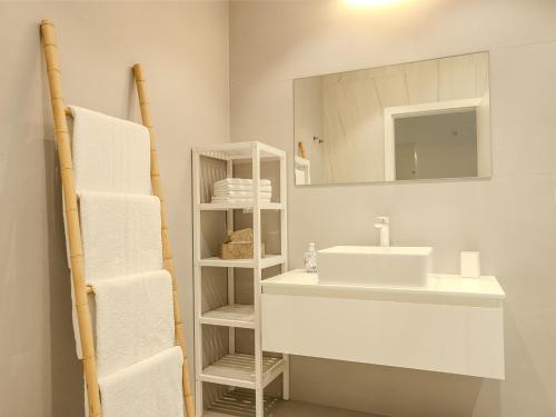 a bathroom with a sink and a mirror and towels at Apartment Rahat in Ližnjan