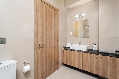 a bathroom with a sink and a toilet and a mirror at Kritamo Suites Sandy Bay in Ayia Napa