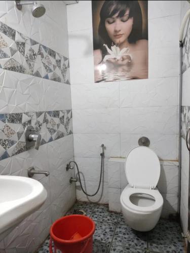 a bathroom with a toilet and a picture of a woman at Amith Comforts near to Railway Station in Mysore