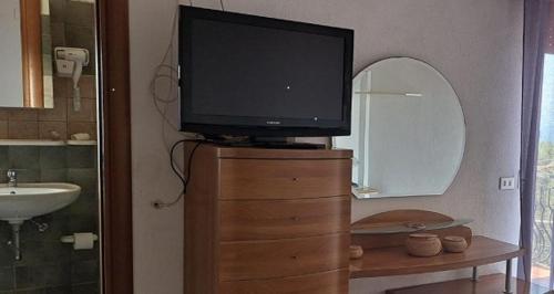 a television on top of a dresser with a mirror at Residence San Antonio in Marina di Camerota