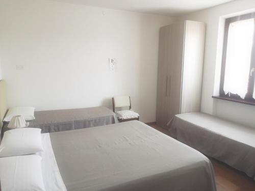 a white room with two beds and a window at Il Gelsomino in Foligno