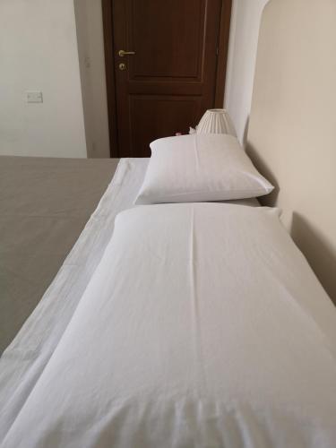 a bed with white sheets and pillows on it at Il Gelsomino in Foligno
