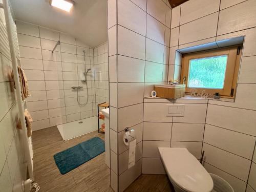 a bathroom with a toilet and a shower and a window at Leiterhütte in Patergassen