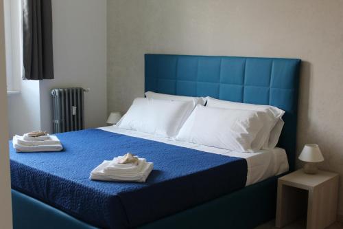 a blue bed with two towels on top of it at SunnyCornerinRHome in Rome