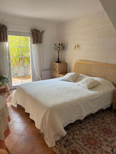a bedroom with a large bed and a window at Paradis Provençal in Sainte-Maxime