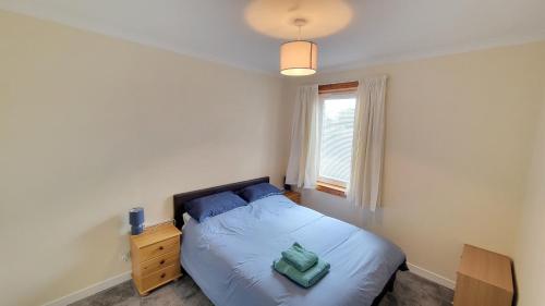 a small bedroom with a bed and a window at Stornoway Stays Apartment in Stornoway