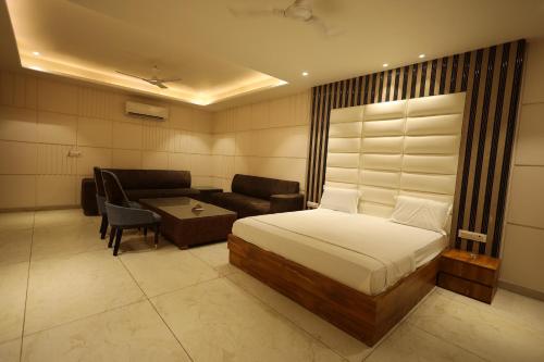 a hotel room with a bed and a couch at Meenar Hotel in Meerut