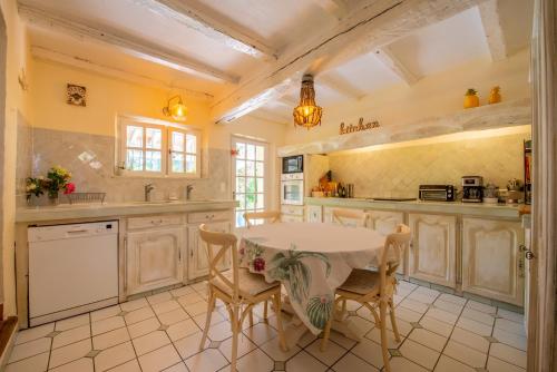 a kitchen with a table and chairs in a room at Paradis Provençal in Sainte-Maxime