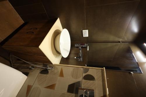 a bathroom with a toilet in a stall at Meenar Hotel in Meerut