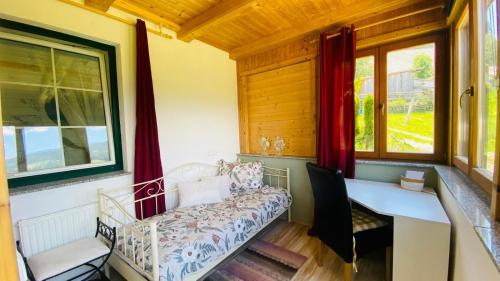 a room with a couch and a desk and a window at BergZeit in Warbach