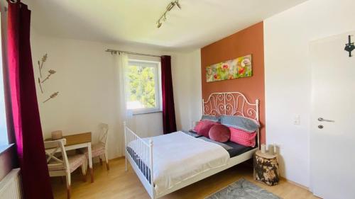a small bedroom with a bed and a desk at BergZeit in Warbach