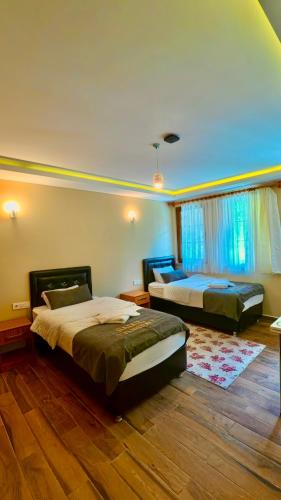 a bedroom with two beds and a large window at Badul Pansiyon in Uzungöl